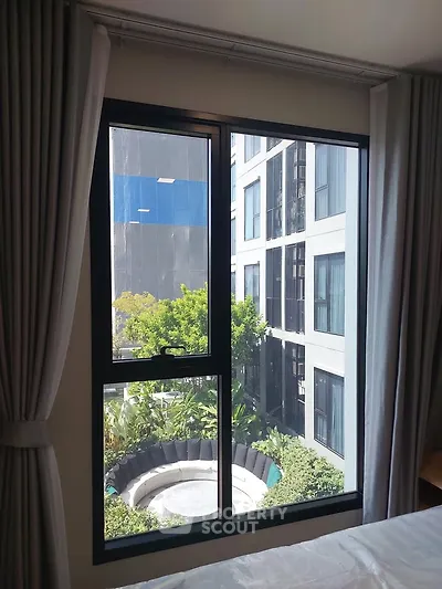 Modern apartment window with garden view and adjacent building