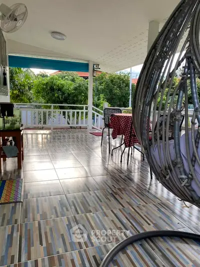 Spacious balcony with modern swing chair and tiled flooring, perfect for relaxation.