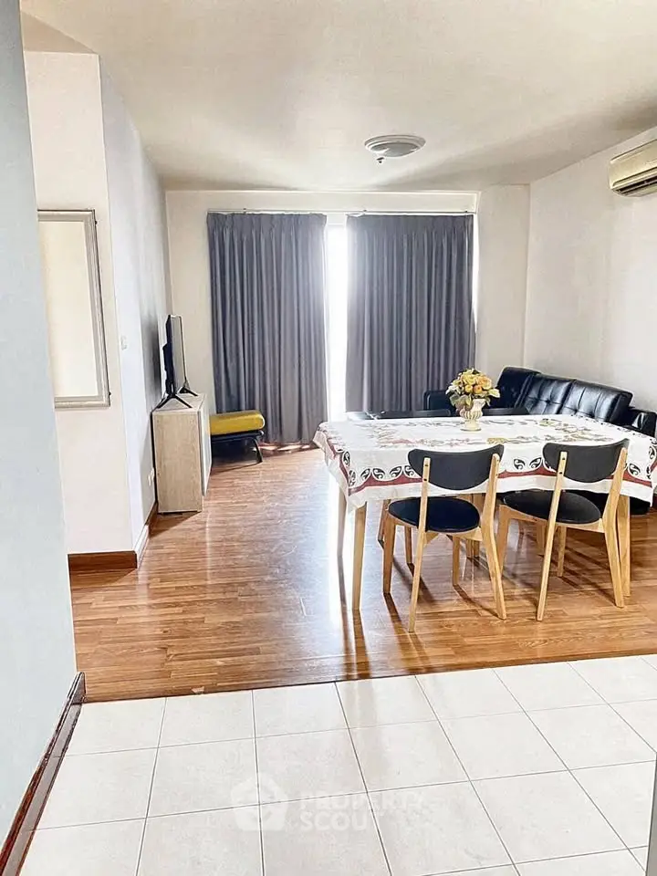 Spacious living room with wooden flooring and modern furniture, perfect for family gatherings.