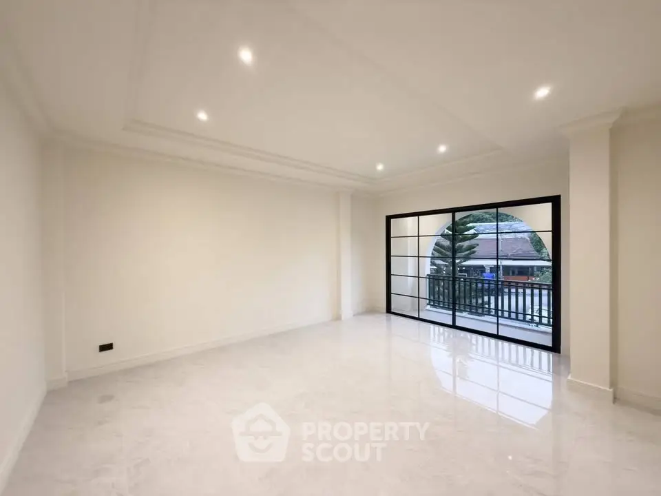 Spacious modern living room with large windows and balcony access