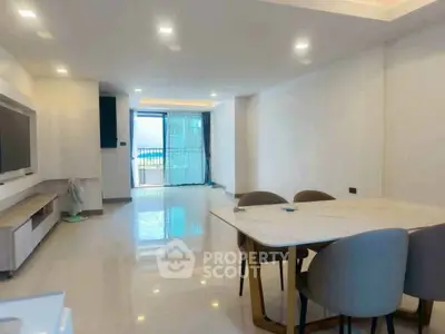 Spacious modern living room with sleek dining area and large windows for natural light.