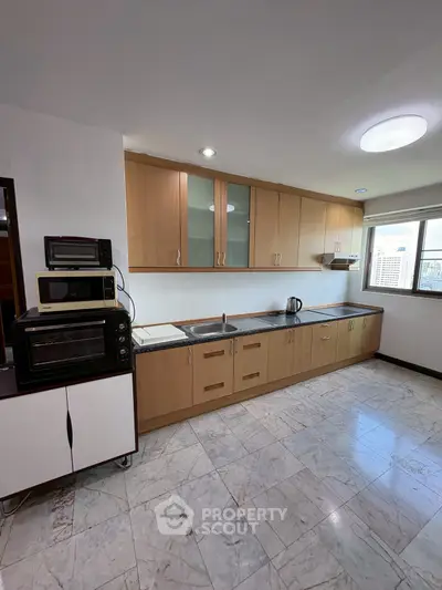 Spacious kitchen with modern appliances and ample storage in a bright apartment.
