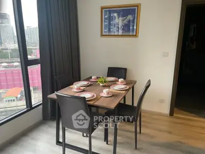 Modern dining area with city view, featuring elegant table setting and large window for natural light.