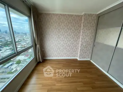 Spacious room with wooden flooring and city view, ideal for customization.