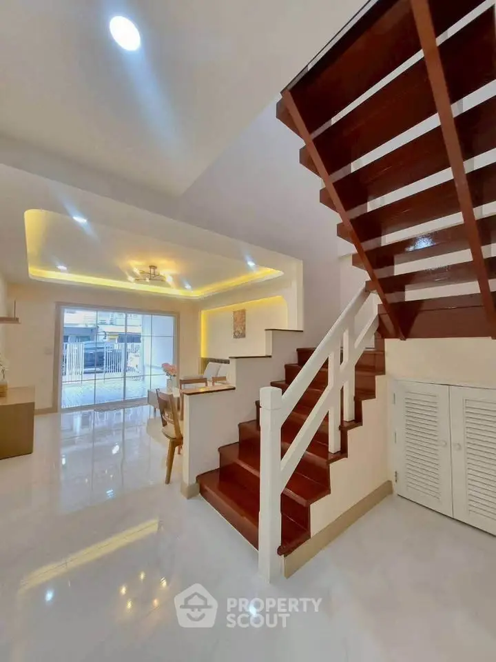 Modern interior with elegant staircase and open living area, featuring sleek design and ample natural light.