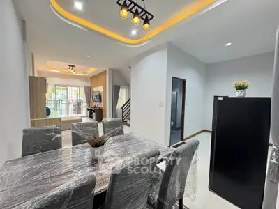 Modern dining and living area with stylish ceiling lights and natural light