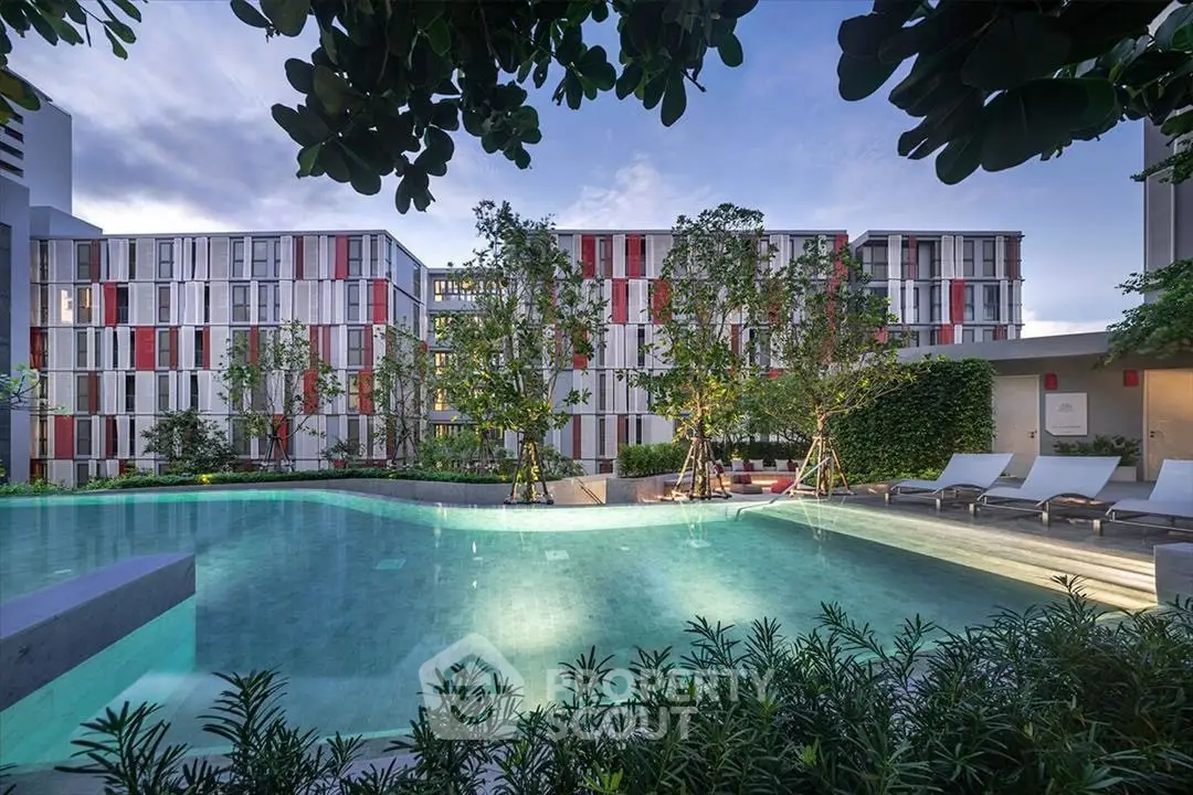 Luxurious modern apartment complex with stunning pool and lush greenery, perfect for relaxation and leisure.