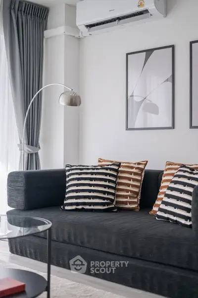 Modern living room with stylish sofa, abstract art, and elegant floor lamp