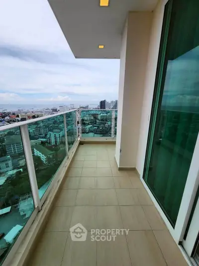 Stunning high-rise balcony with panoramic city views and modern glass railing.