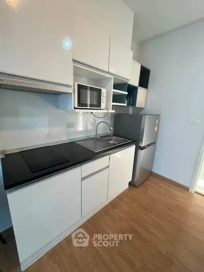 Modern kitchen with sleek cabinetry and stainless steel appliances in a stylish apartment.