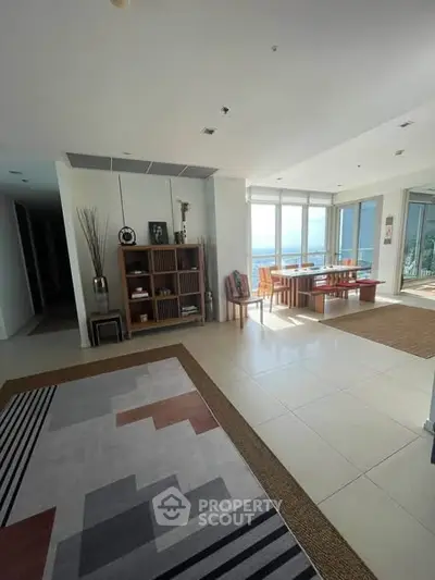 Spacious living room with modern decor and stunning ocean view, perfect for relaxation and entertainment.