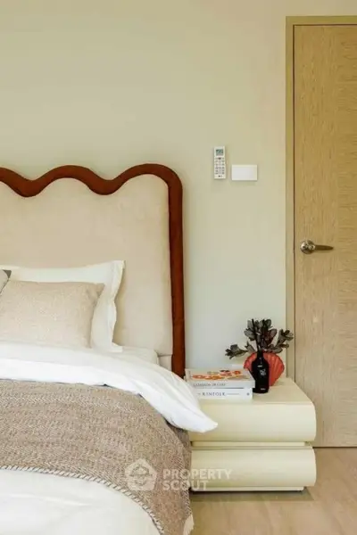 Cozy bedroom with stylish headboard and modern decor, perfect for relaxation and comfort.