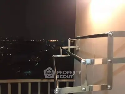 Stunning night view from a balcony with sleek metal railing, perfect for city living.