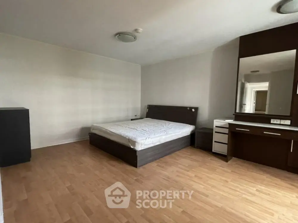 Spacious bedroom with modern furniture and wooden flooring