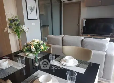 Modern living room with elegant dining setup and cozy seating area, perfect for stylish urban living.