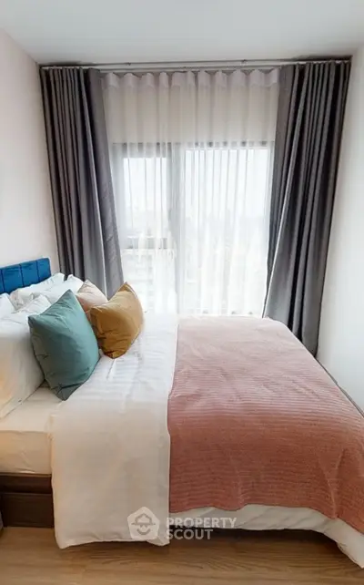 Cozy bedroom with large window and stylish decor in modern apartment