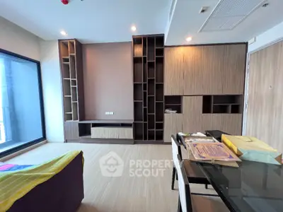 Modern living room with built-in wooden shelves and large window view.
