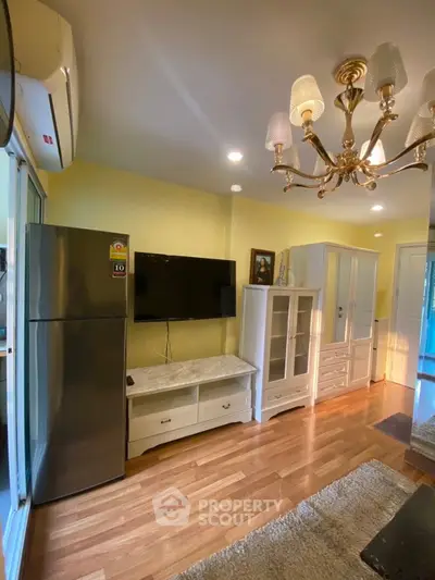 Charming living room with elegant chandelier and modern appliances, perfect for cozy gatherings.