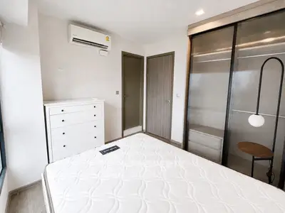 Modern bedroom with sleek wardrobe and air conditioning in a stylish apartment.