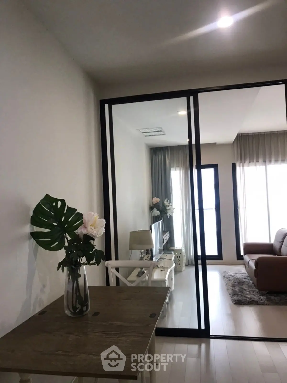 Modern living room with glass partition and stylish decor