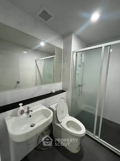 Modern bathroom with sleek shower and elegant fixtures in a contemporary apartment.