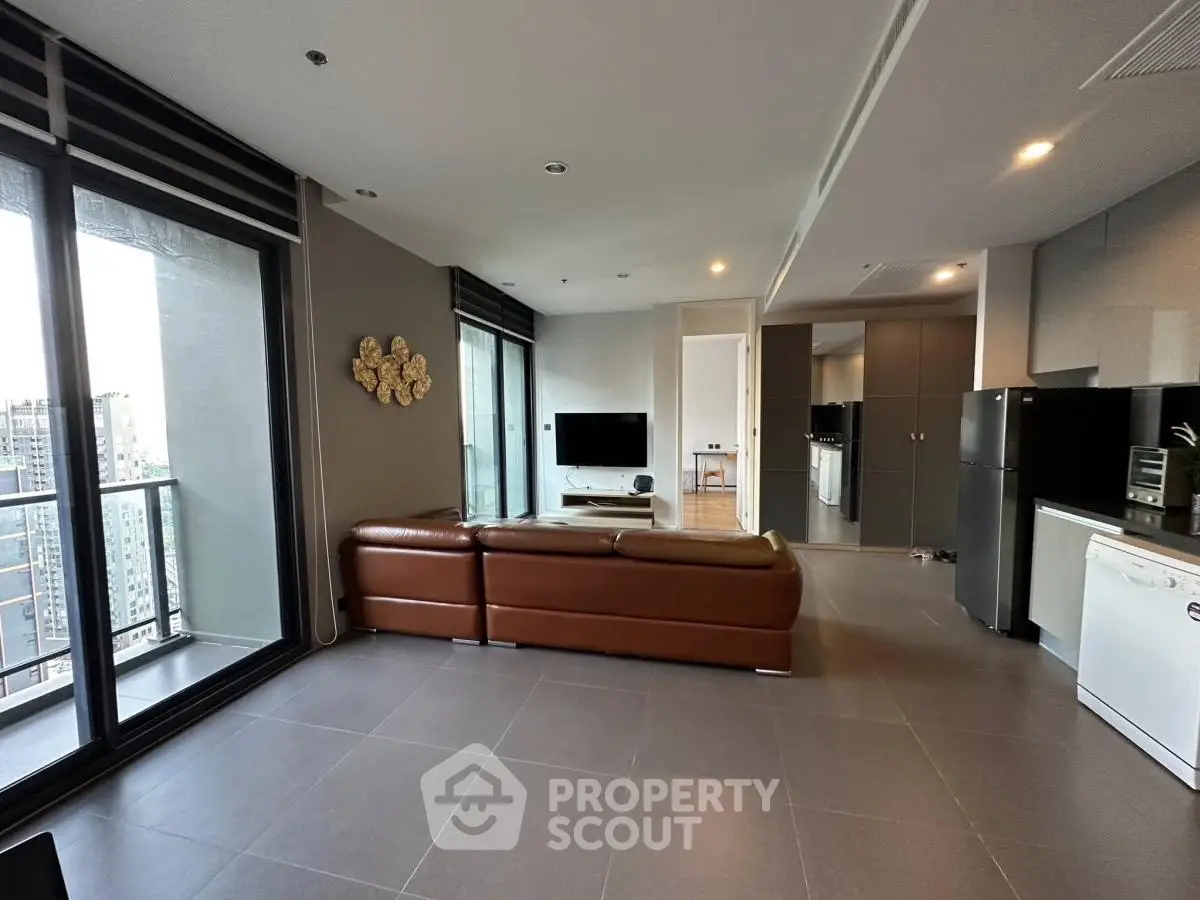 Modern living room with open kitchen and balcony view in urban apartment