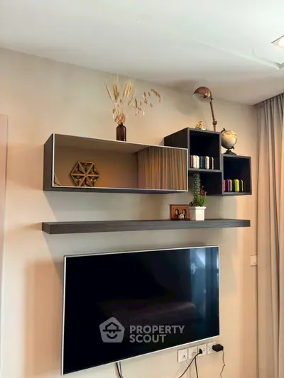 Modern living room with wall-mounted TV and stylish shelves