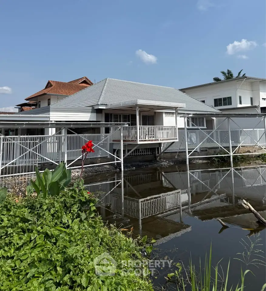 Charming waterfront house with a spacious deck and serene pond view, perfect for tranquil living.