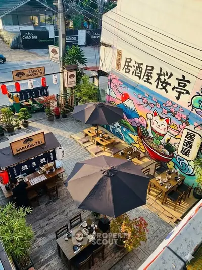 Charming outdoor dining area with Japanese decor and vibrant mural, perfect for a unique dining experience.