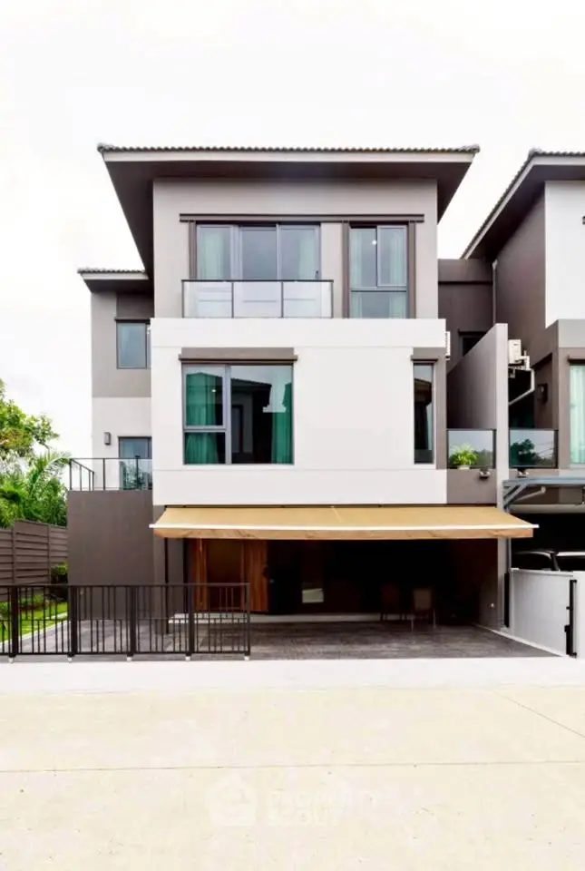 Modern multi-story townhouse with sleek design and spacious balcony in a serene neighborhood.