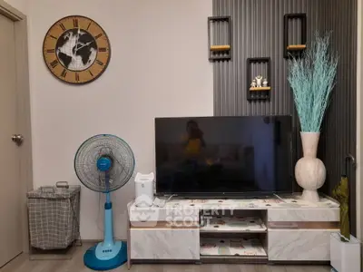Modern living room with stylish decor, featuring a large TV, elegant clock, and decorative shelves.
