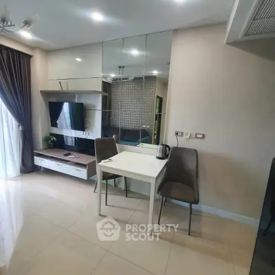 Modern living room with sleek design, mirrored wall, and cozy dining area.
