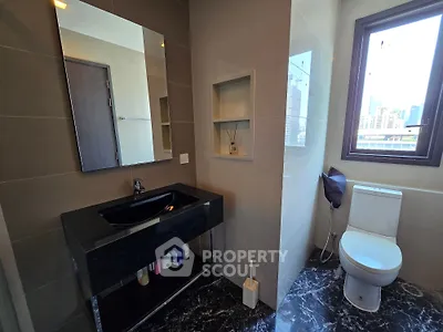 Modern bathroom with sleek black sink and city view window