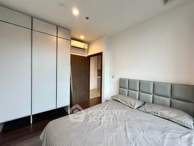 Modern bedroom with sleek wardrobe and air conditioning in a stylish apartment.