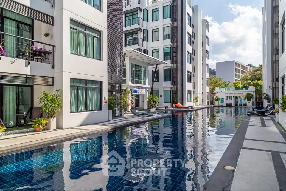 Modern apartment complex with luxurious pool and sun loungers