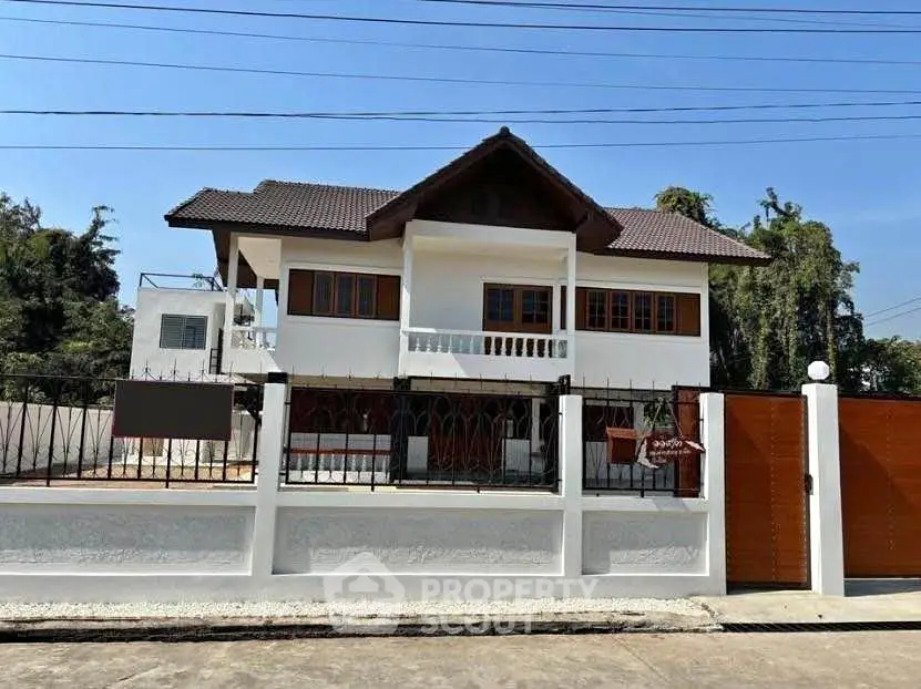 Charming two-story house with traditional roof and spacious fenced yard.