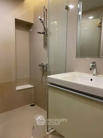 Modern bathroom with sleek shower and stylish sink in contemporary design.