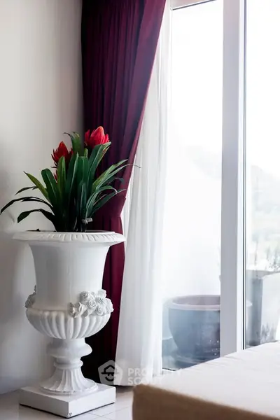 Elegant interior with large window and decorative plant in stylish vase