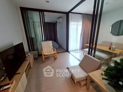 Modern living room with stylish furniture and natural light, featuring a cozy seating area and a TV unit.