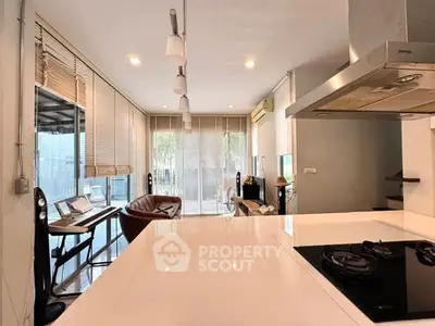 Modern open-layout living room with sleek kitchen and large windows
