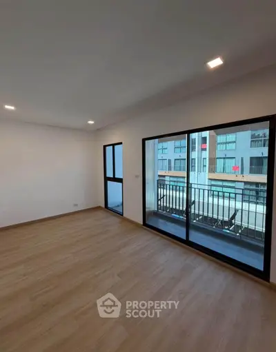 Spacious modern living room with large windows and balcony view