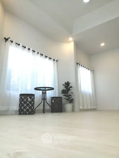 Spacious and bright living room with modern decor and large windows.