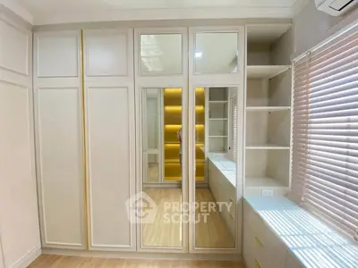 Spacious bedroom with mirrored wardrobe and ample natural light
