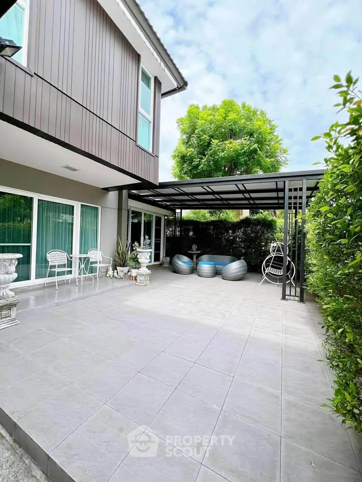 Spacious modern patio with elegant seating and lush greenery, perfect for outdoor relaxation.