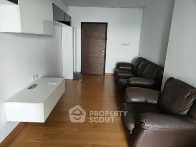 Spacious living room with leather sofas and wooden flooring