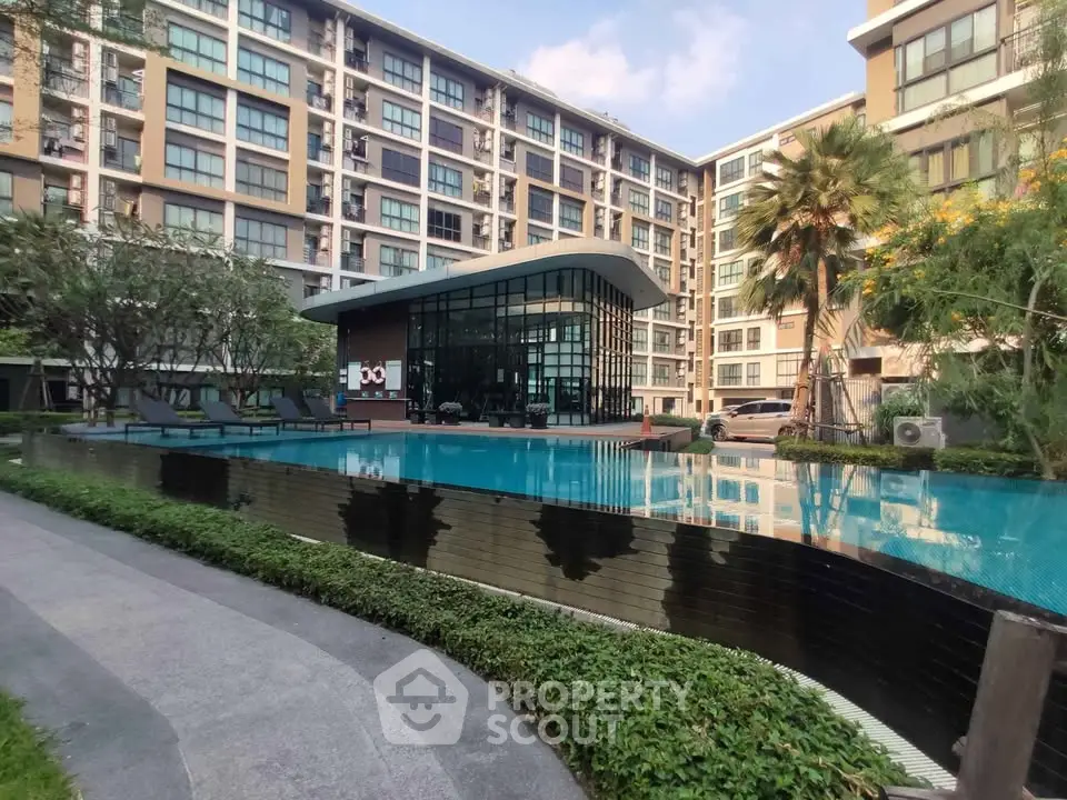 Modern apartment complex with luxurious pool and lush landscaping