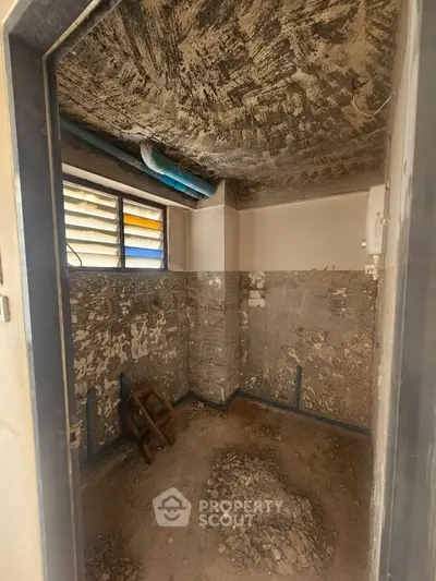 Under-construction room with exposed walls and ceiling, showcasing renovation potential.