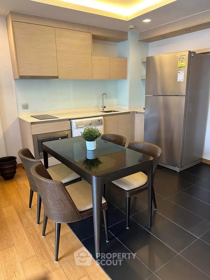 Modern kitchen with sleek dining area and stainless steel appliances in a stylish apartment.