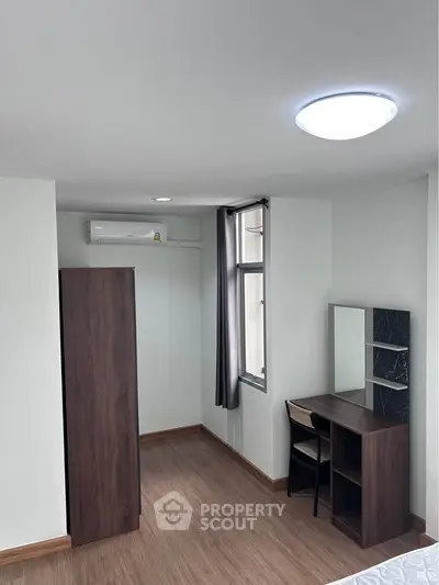 Modern bedroom with wooden flooring and sleek furniture