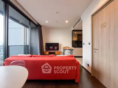 Modern living room with red sofa and city view, open kitchen layout.